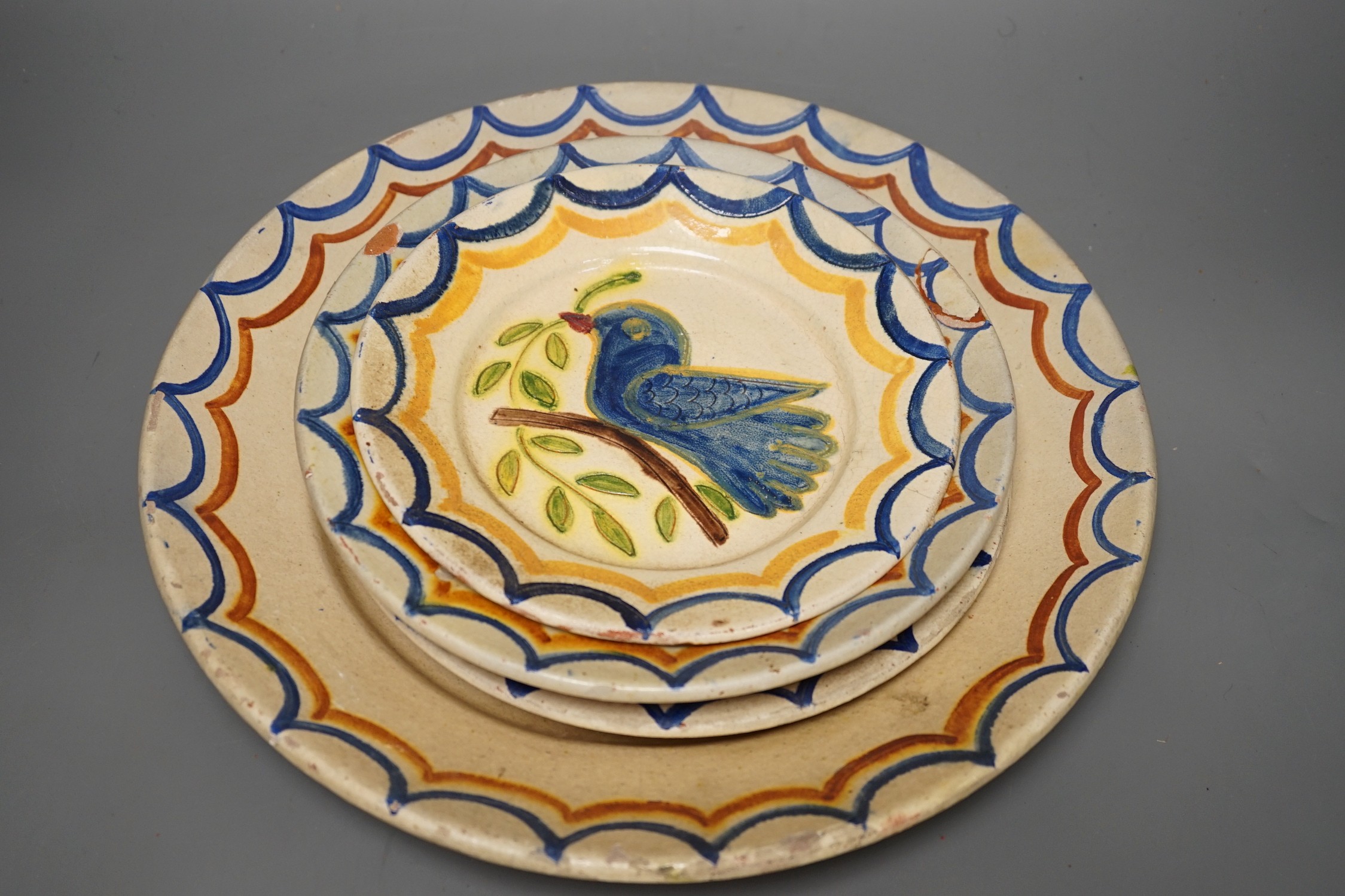 Five Portuguese provincial pottery plates, largest 35 cms diameter